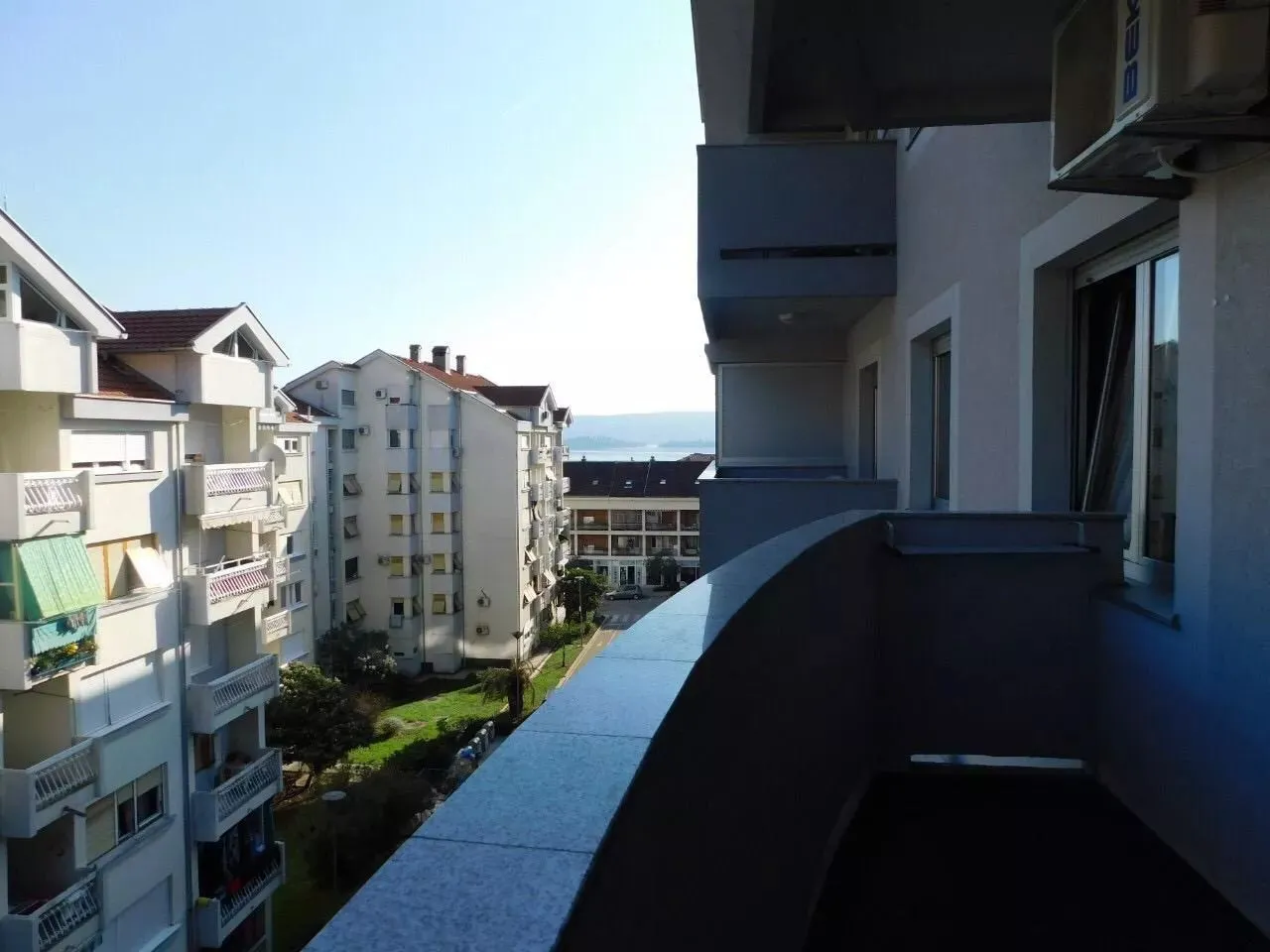 Pogled sa balkona na okolne zgrade i naselje.