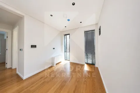 Empty bright room with parquet flooring and two narrow windows with blinds. - image 3