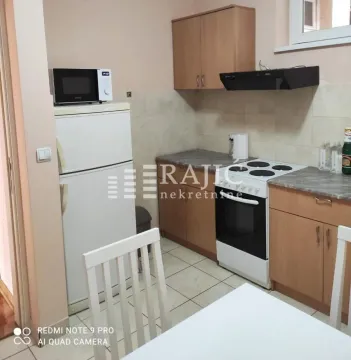 Small kitchen with wooden cabinets and white goods. - image 4