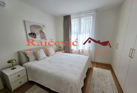 Furnished bedroom with a double bed, bedside tables, and a wardrobe. - image 3