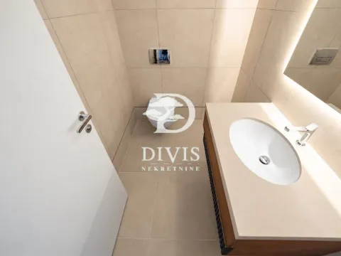 Modern bathroom with a washbasin and toilet, tiled with ceramic tiles. - image 11