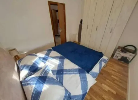 Spavaća soba sa bračnim krevetom, plakarom i drvenim podom. - image 4