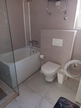 Kupatilo opremljeno kadom, toaletom i tuš kabinom sa staklenom pregradom. - image 8