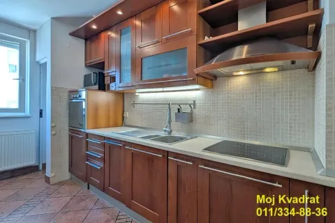 Kitchen equipped with wooden cabinets, a sink, and built-in appliances. - image 3