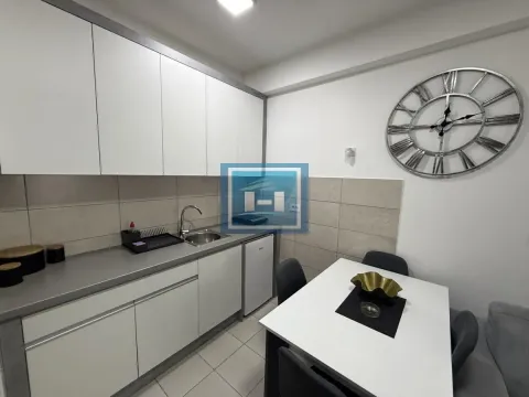 Modern kitchen with white units and a dining table. - image 4