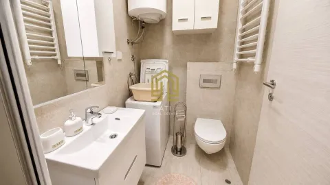 Modern bathroom with a sink, toilet, and washing machine. - image 8