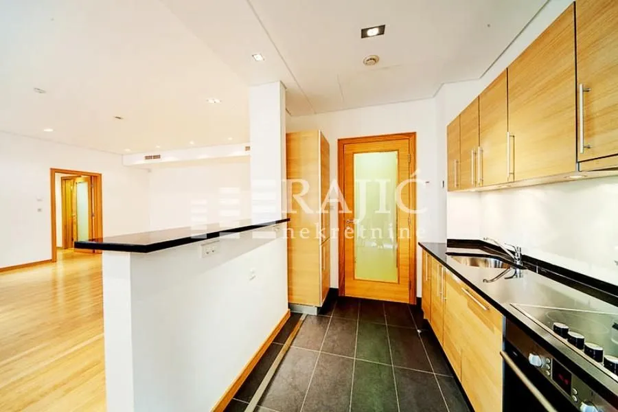 Modern kitchen with wooden cabinetry open to the living area.