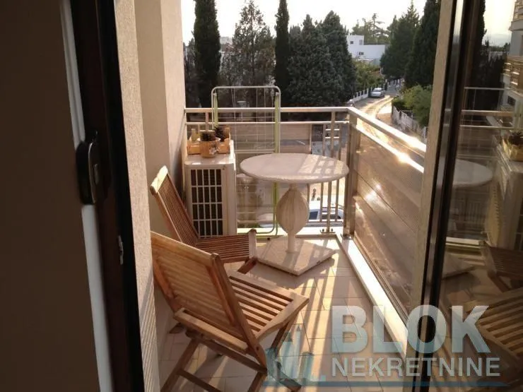 Furnished balcony with a table, chairs, and a view of the surroundings.