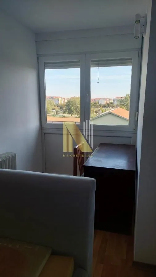 Smaller room with a desk and a view through the window.