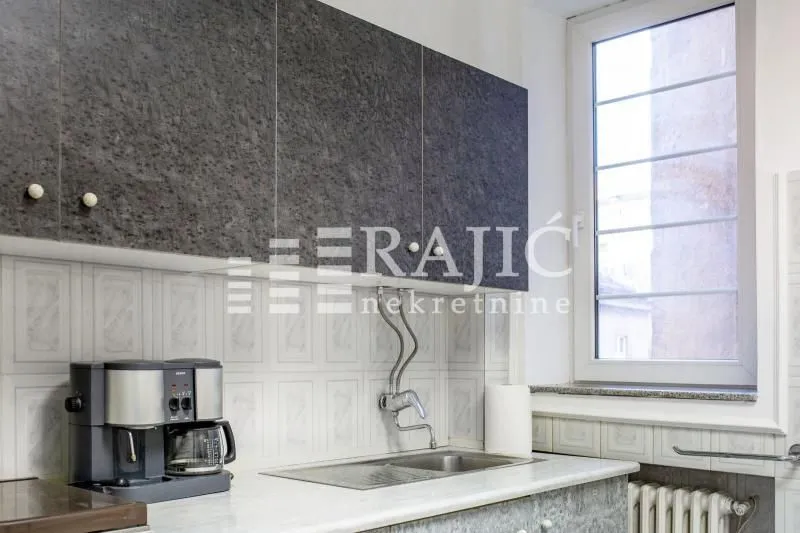 Part of the kitchen with a sink, countertop, and wall cabinets.