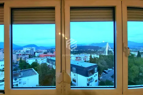 View of the city with a bridge and mountains in the background through a window. - image 10