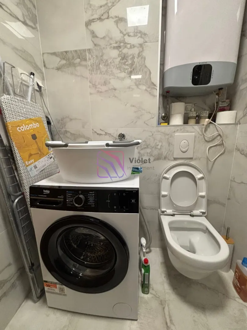 Kupatilo opremljeno WC šoljom, veš mašinom i bojlerom.