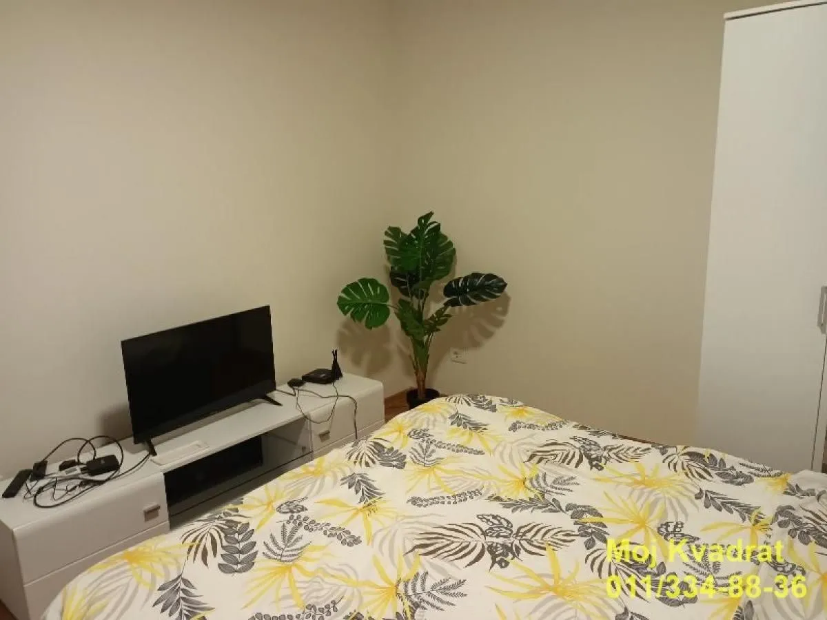 Furnished bedroom with a double bed, TV, and wardrobe.