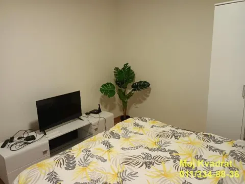 Furnished bedroom with a double bed, TV, and wardrobe. - image 6