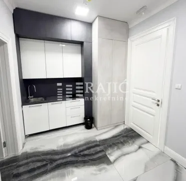 Small kitchen with white and dark cabinets and marble tiles. - image 11