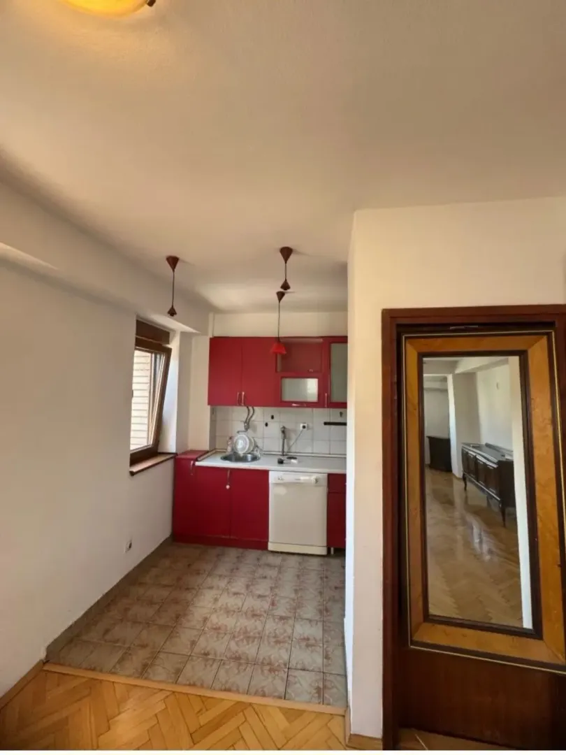 Kitchen with red cabinets and tiled flooring.