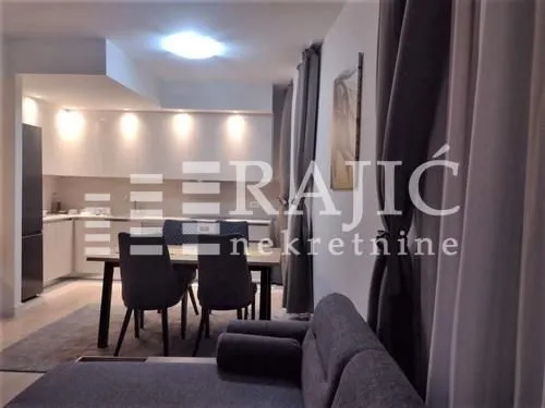Living room with dining area and view of the kitchen.