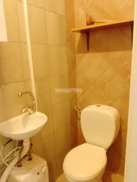 Small tiled bathroom with a toilet and a sink. - image 4