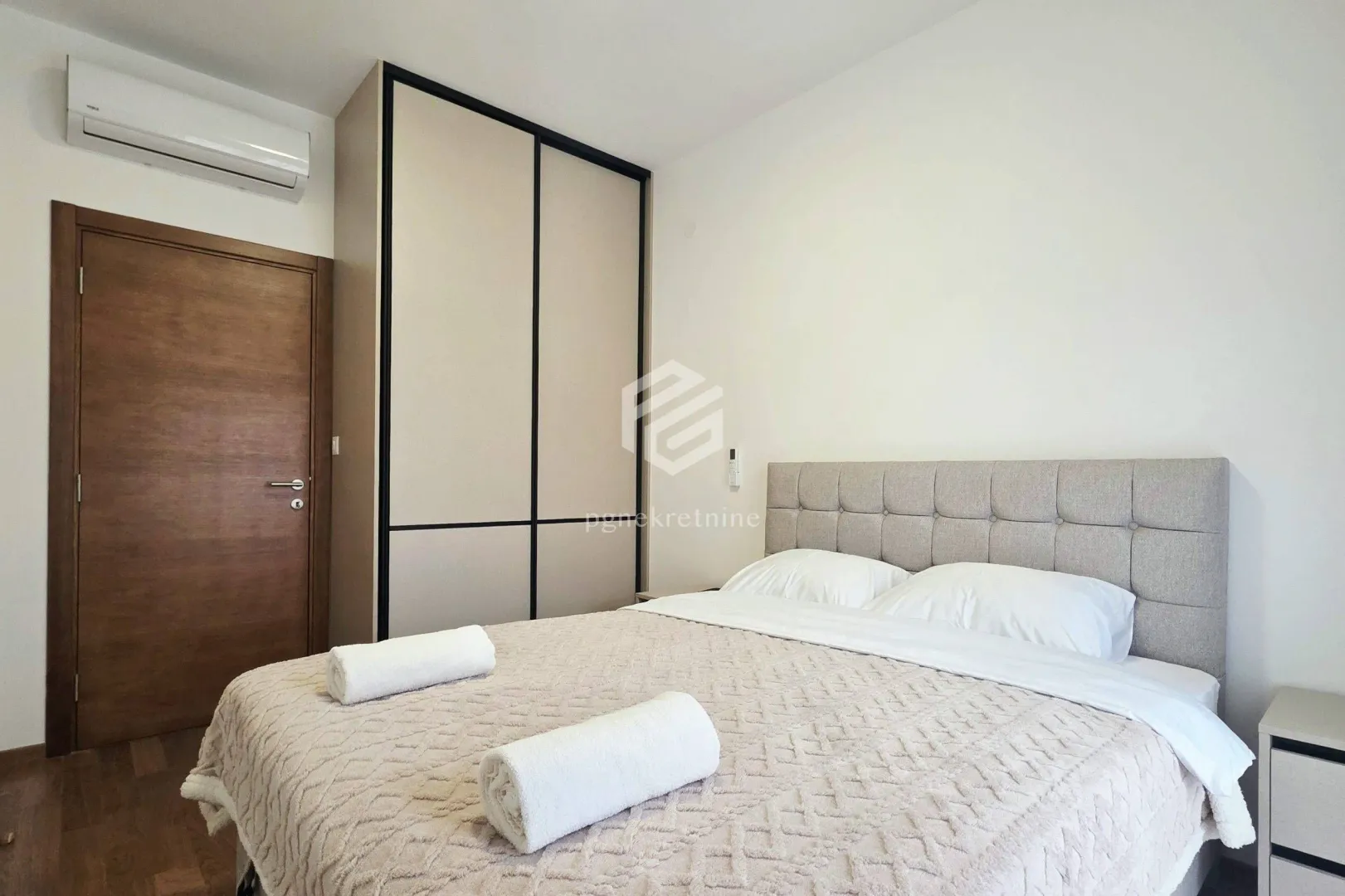 Furnished bedroom with a double bed, wardrobe, and air conditioning.