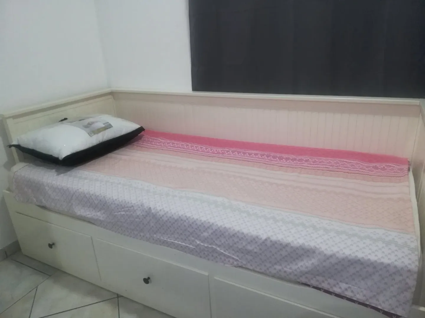 Single bed with drawers in a bedroom.