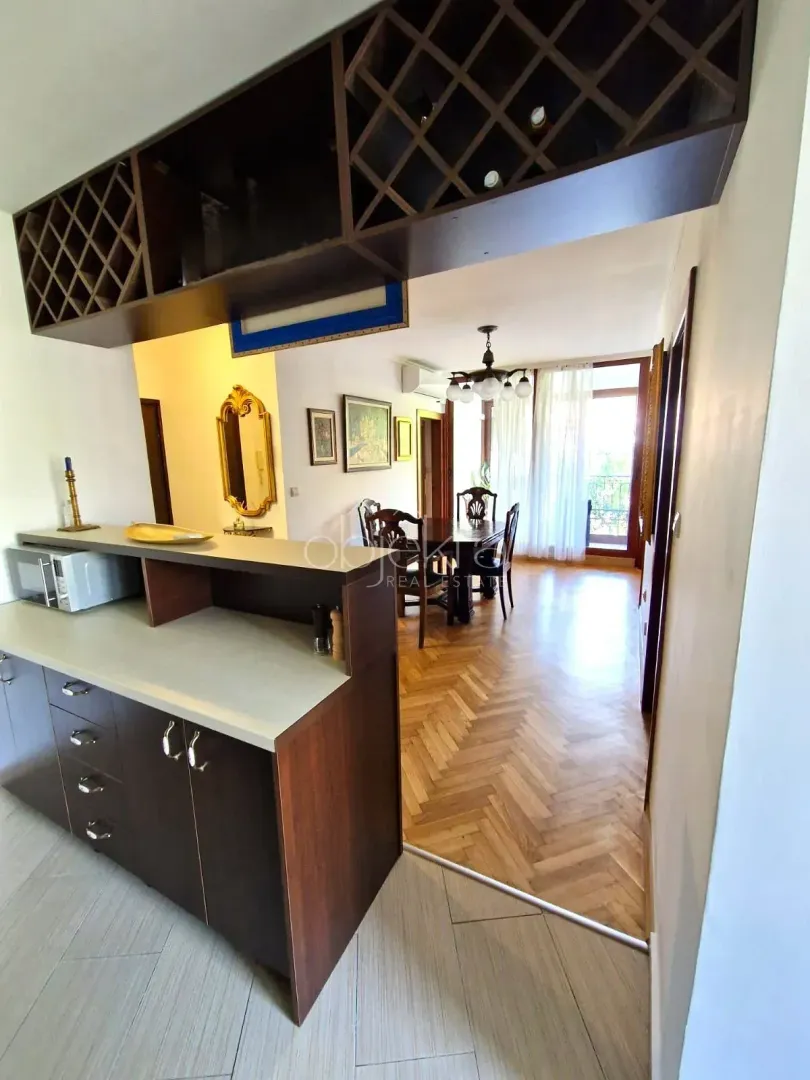 View from the kitchen towards the dining area with wooden furniture and parquet flooring.