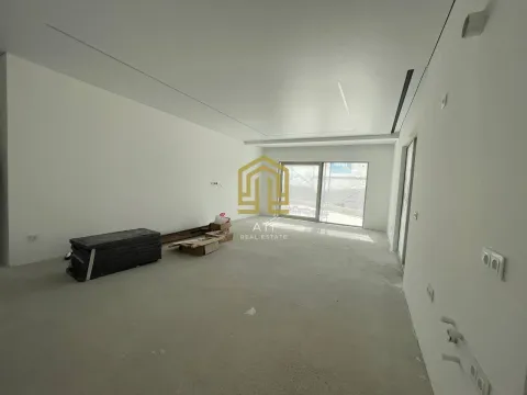 Prazna prostorija u izgradnji sa bijelim zidovima i velikim prozorom. - image 3