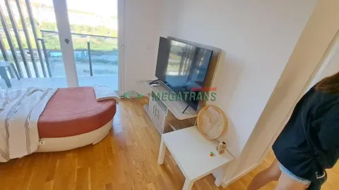 Pogled na deo spavaće sobe sa krevetom i televizorom. - image 4