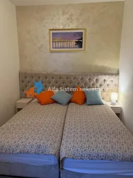 Nameštena spavaća soba sa velikim bračnim krevetom i ukrasnim uzglavljem. - image 11