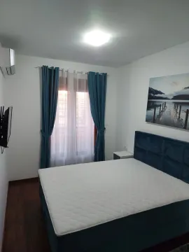 Bedroom with a double bed, blue curtains, and a wall painting. - image 7
