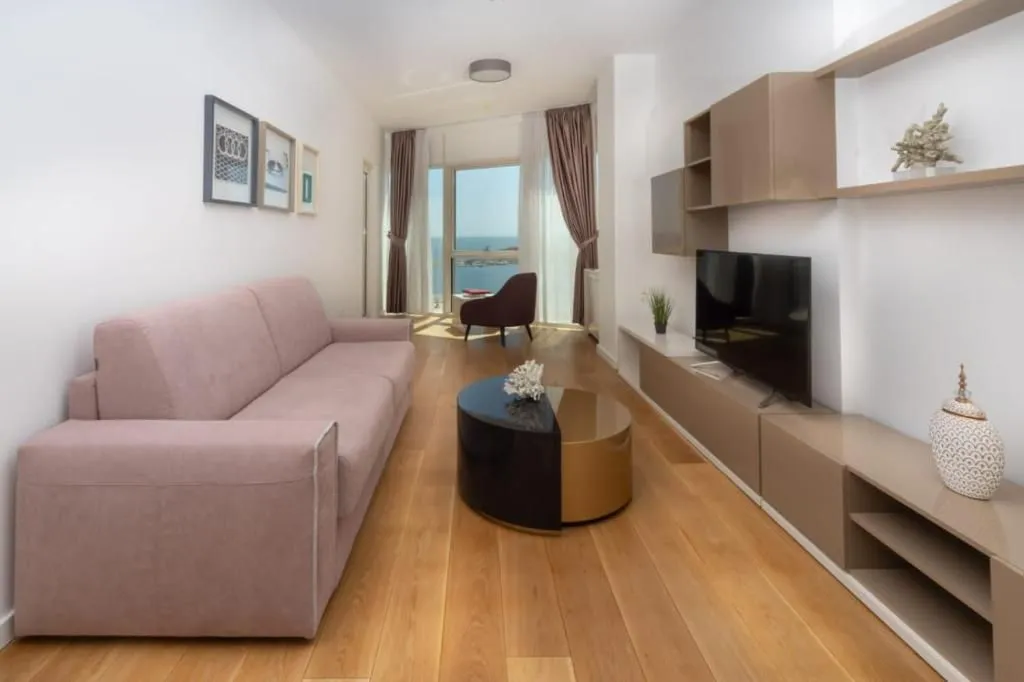 Spacious and bright living room with a sofa and a sea view.