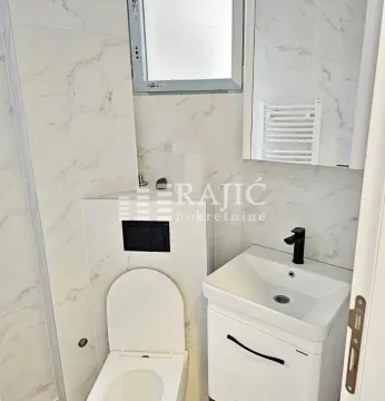 Pogled na moderno opremljeno kupatilo sa sanitarijama i mermernim pločicama. - image 8
