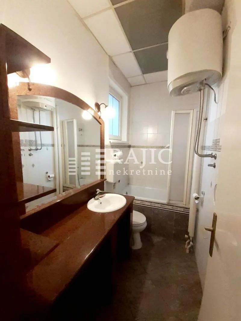 View of the bathroom with a sink, mirror, and bathtub.