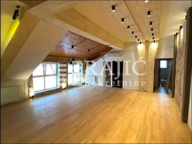Spacious bright living room with wooden flooring and a dropped ceiling with lighting.