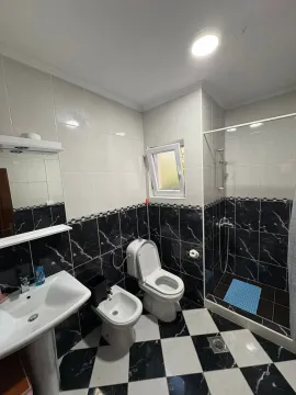 Fully equipped bathroom with a shower cabin and black and white tiles. - image 11