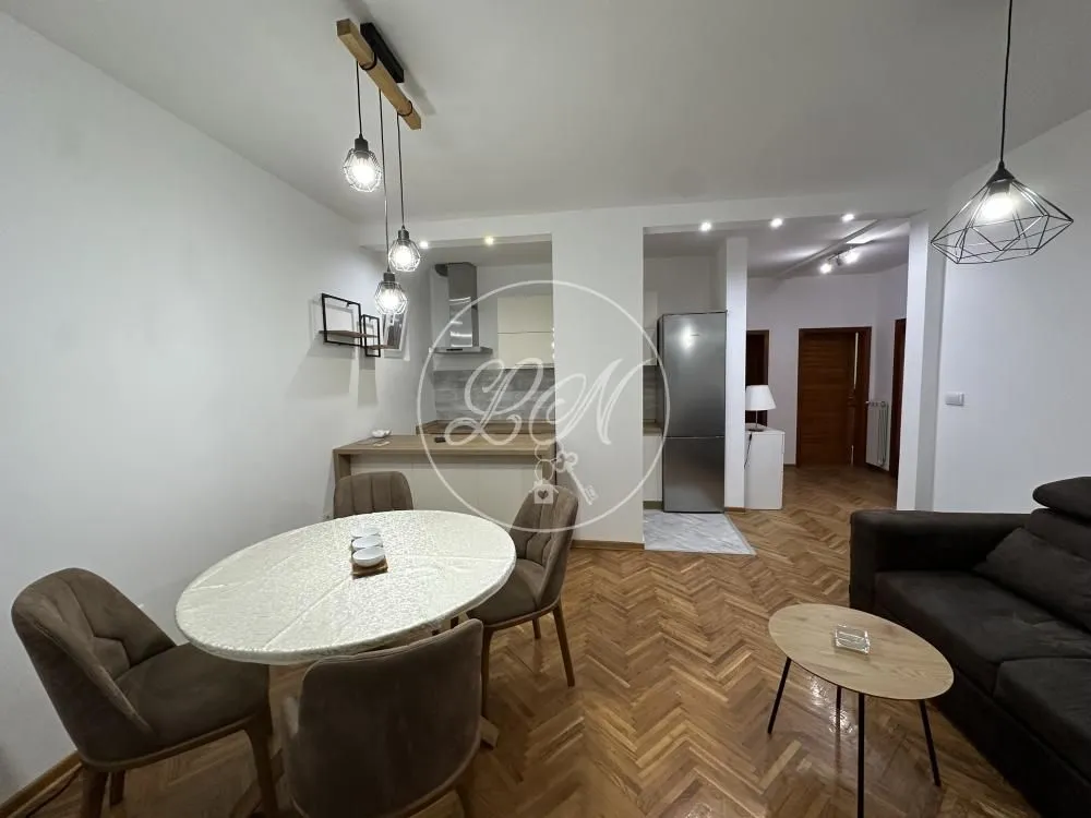 Living room with dining area and part of the kitchen in the background.