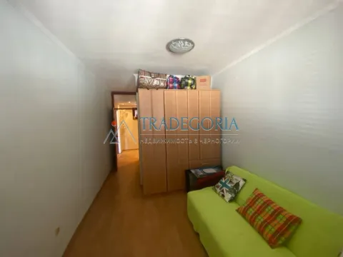 Manja dnevna soba sa zelenom sofom i drvenim ormarom. - image 4