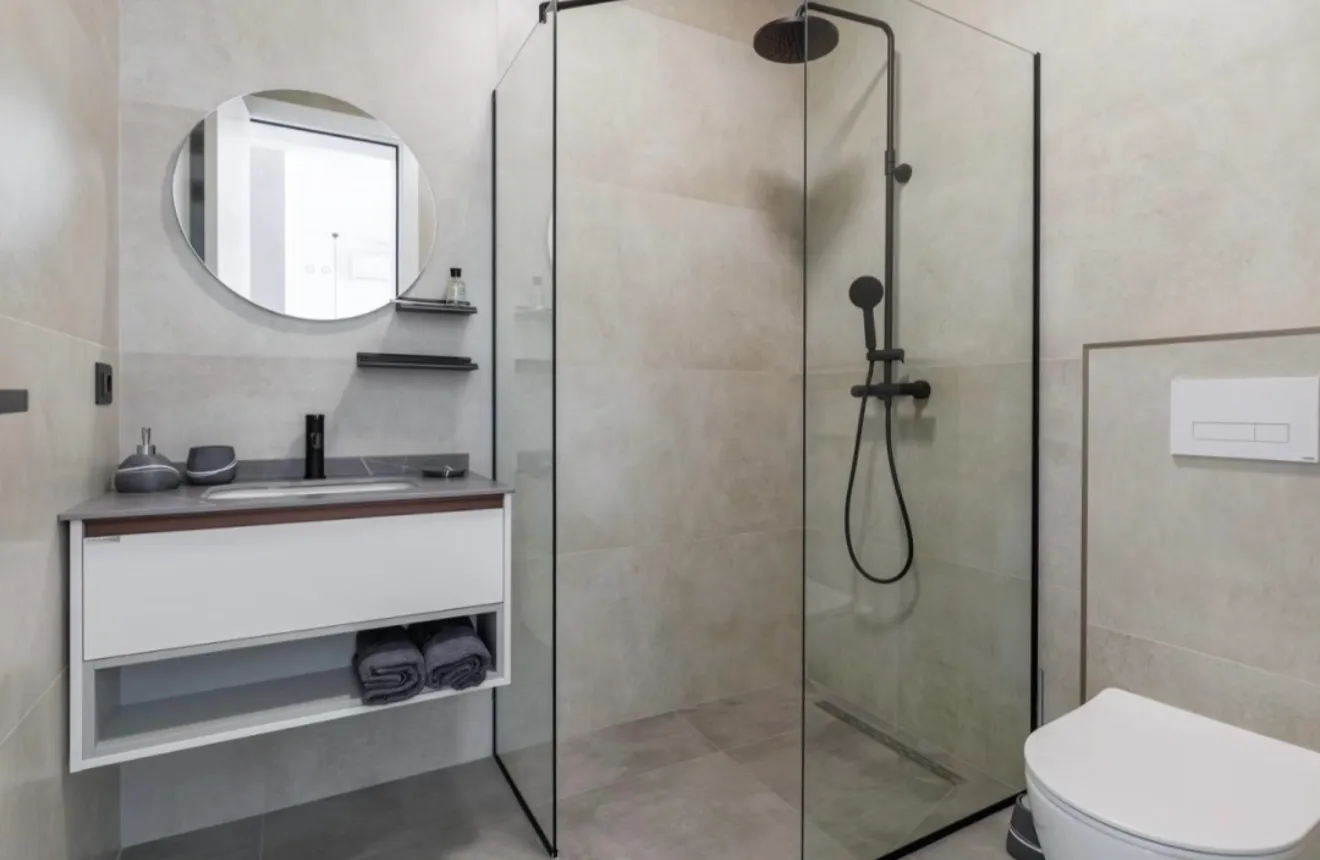 Moderne kupatilo sa tuš kabinom, umivaonikom i WC šoljom.