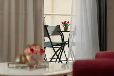 Pogled kroz prozore na namještenu terasu sa stolom i stolicama. - image 5