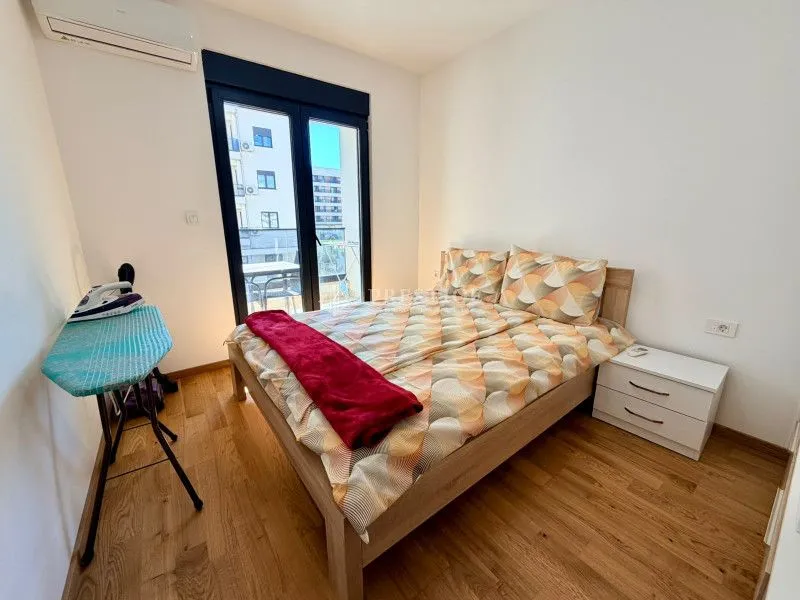 Furnished bedroom with a double bed, nightstand, and access to the terrace.