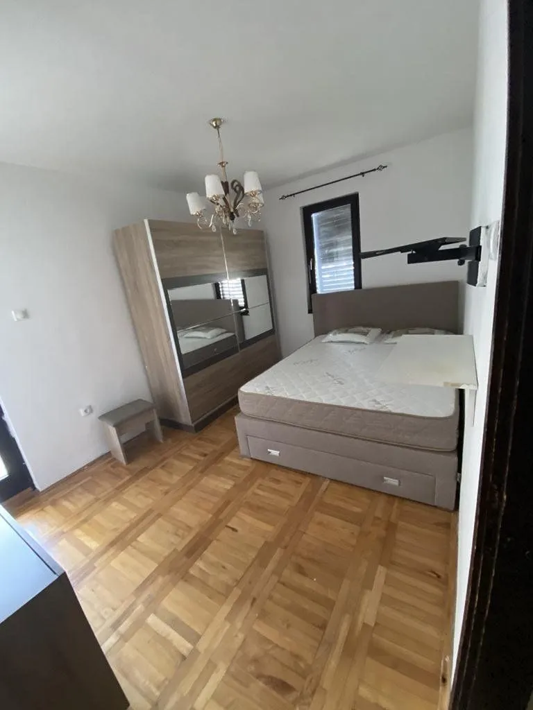 Furnished bedroom with a double bed, wardrobe, and parquet flooring.