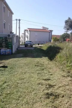 Dvorište sa pokošenom travom pored stambene zgrade. - image 2