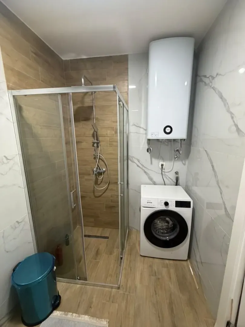 Moderne kupatilo sa tuš kabinom, veš mašinom i bojlerom.