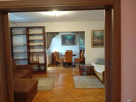 View from the doorway into the living room and dining area with wooden furniture. - image 5