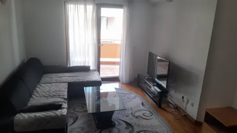 Svijetla dnevna soba sa ugaonom garniturom, klub stolom i televizorom pored balkona. - image 2