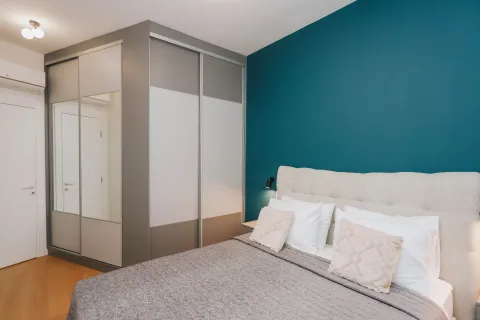 Modern bedroom with a double bed, large wardrobe, and a blue accent wall. - image 15