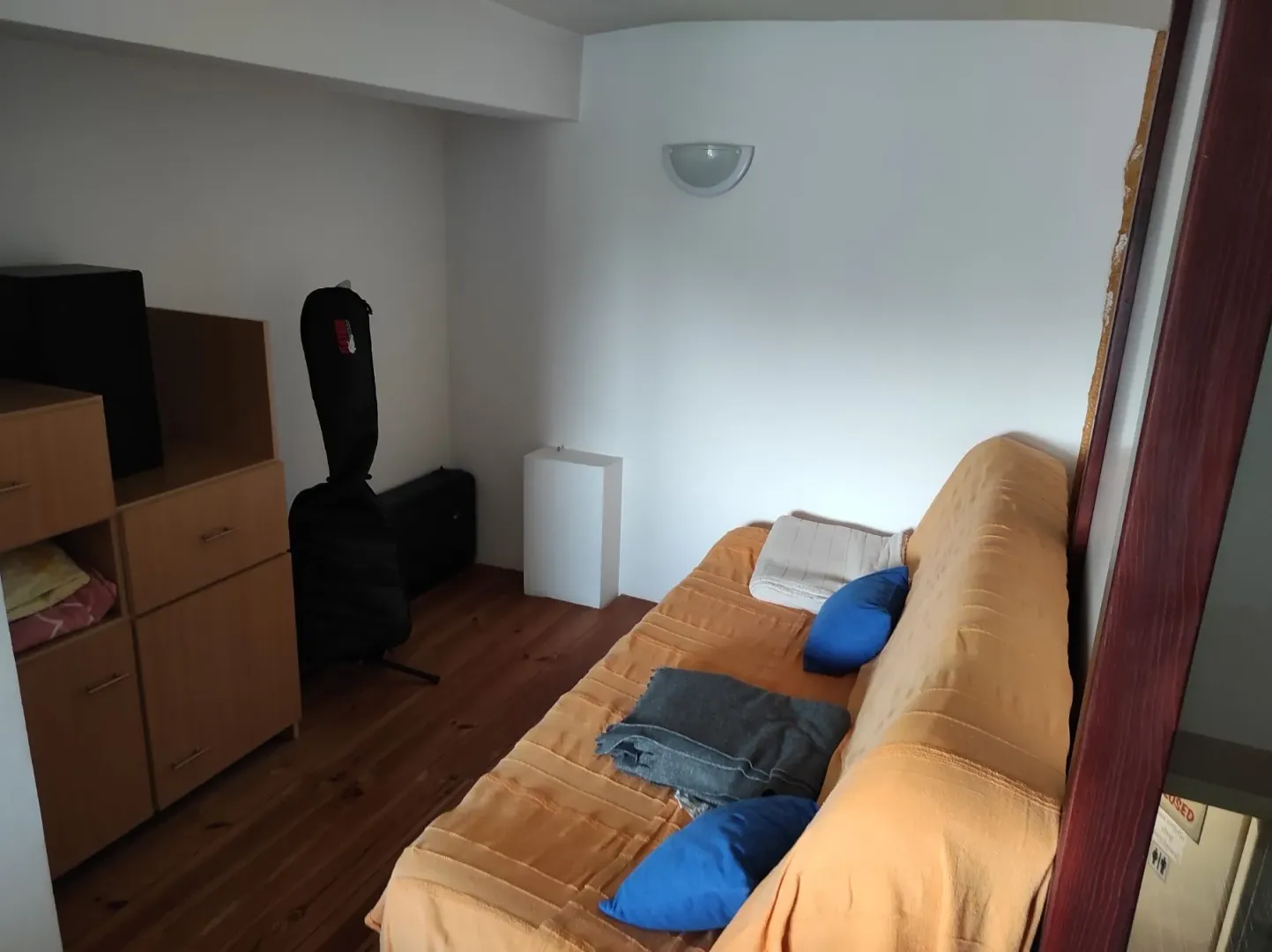 Simple room with a sofa and wooden cabinets.