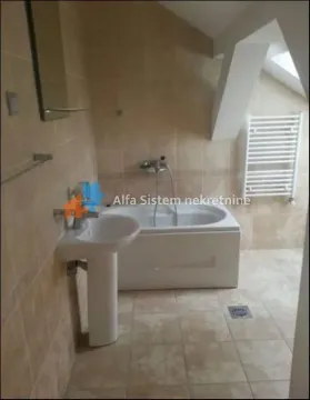 Bathroom tiled with ceramic tiles featuring a bathtub, washbasin, and towel radiator. - image 9