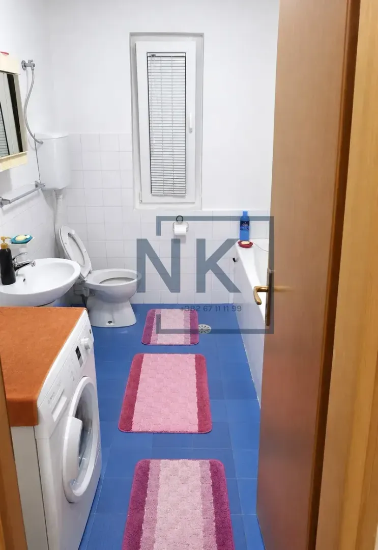 Bathroom with a bathtub, washbasin, toilet, and washing machine.