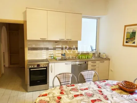 Smaller kitchen with a dining table and built-in appliances. - image 9