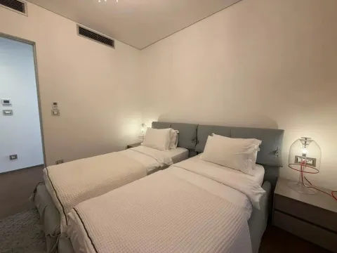 Spavaća soba sa dva odvojena kreveta i noćnim stočićima sa lampama. - image 8